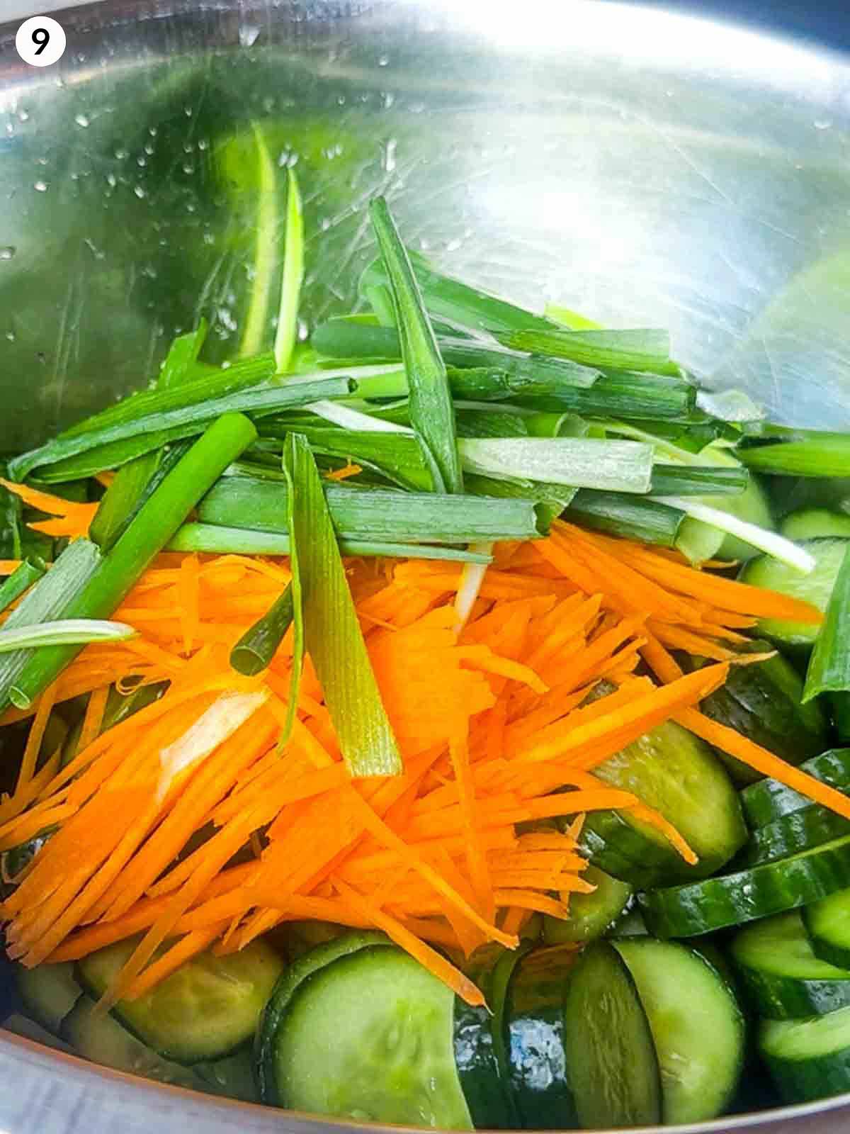 Julienned carrots and scallions added to cucumbers before tossing everything with Korean chili paste to make Oi Kimchi.