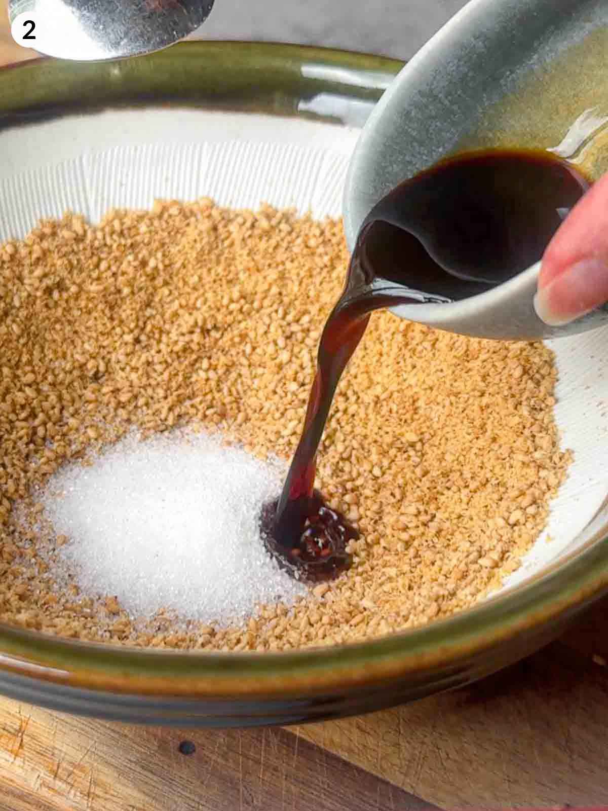 Adding soy sauce and sugar to freshly ground sesame seeds in a suribachi bowl to create authentic Japanese gomae sesame sauce for green beans.