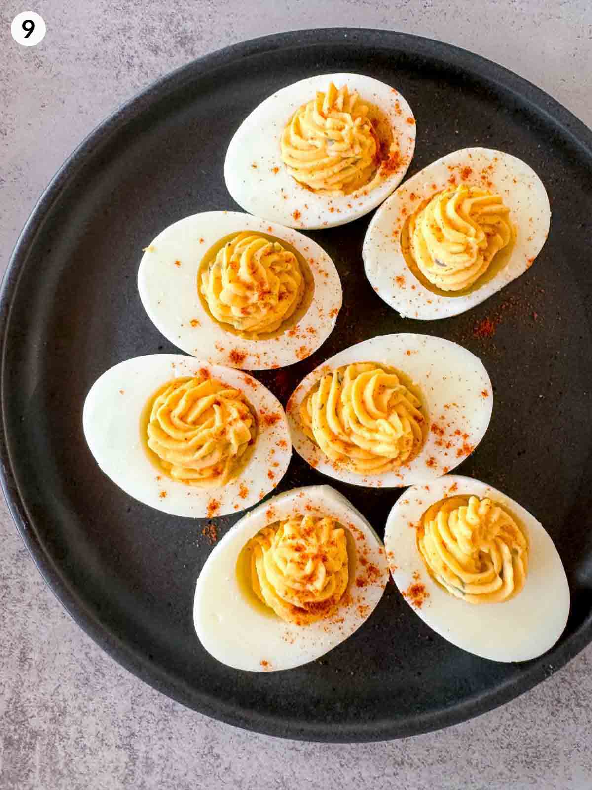 Plated deviled eggs filled with smooth yolk mixture and sprinkled with paprika for garnish, ready to serve as an easy make-ahead appetizer.