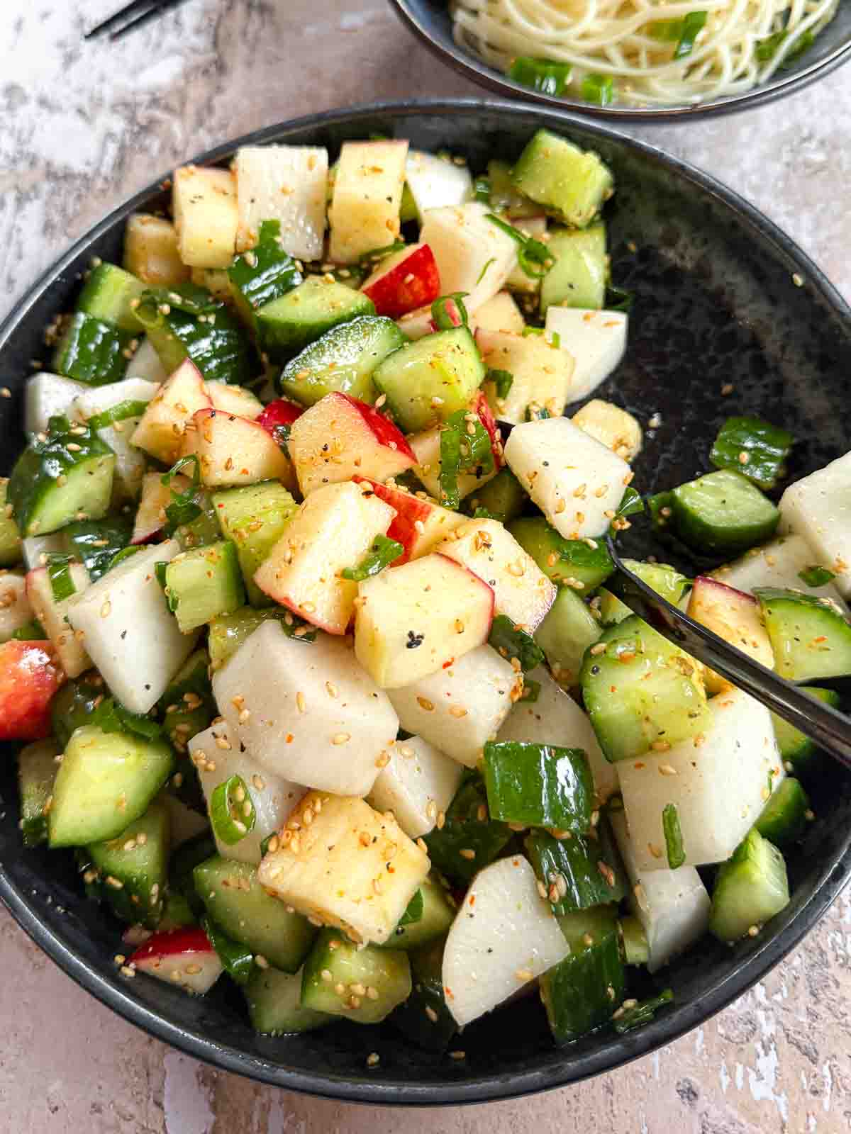 Daikon Cucumber Apple Salad with Togarashi Dressing served with noodles
