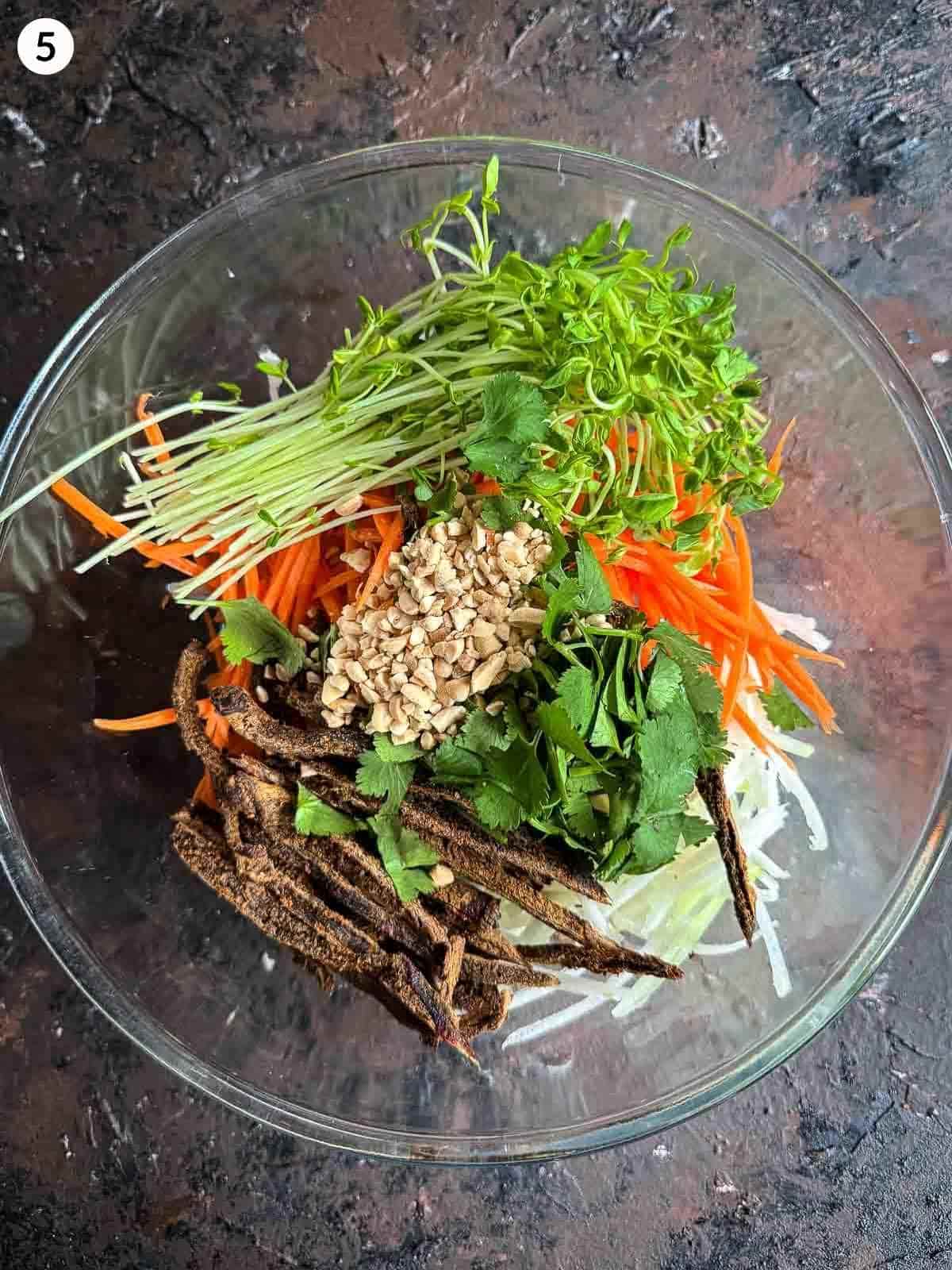 A clear mixing bowl of Asian Slaw Recipe with Beef Jerky and Kohlrabi ingredients