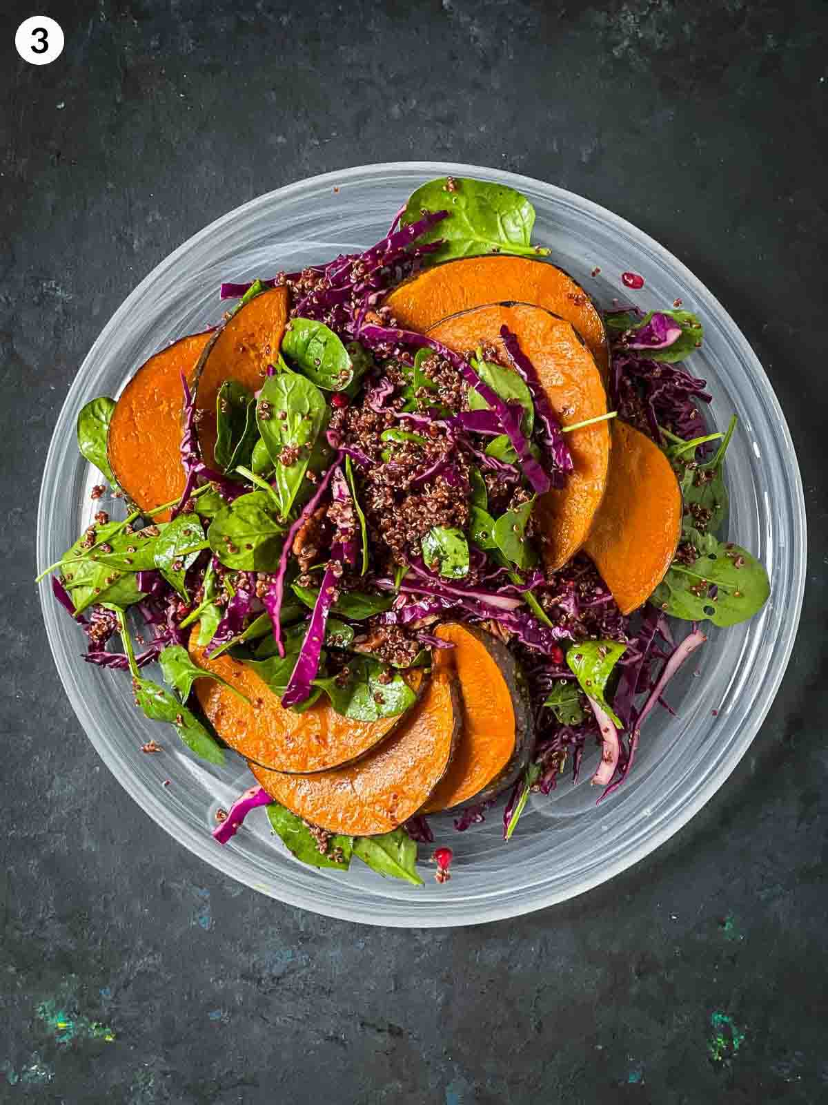 Assembling Quinoa Pumpkin Salad on a large white platter