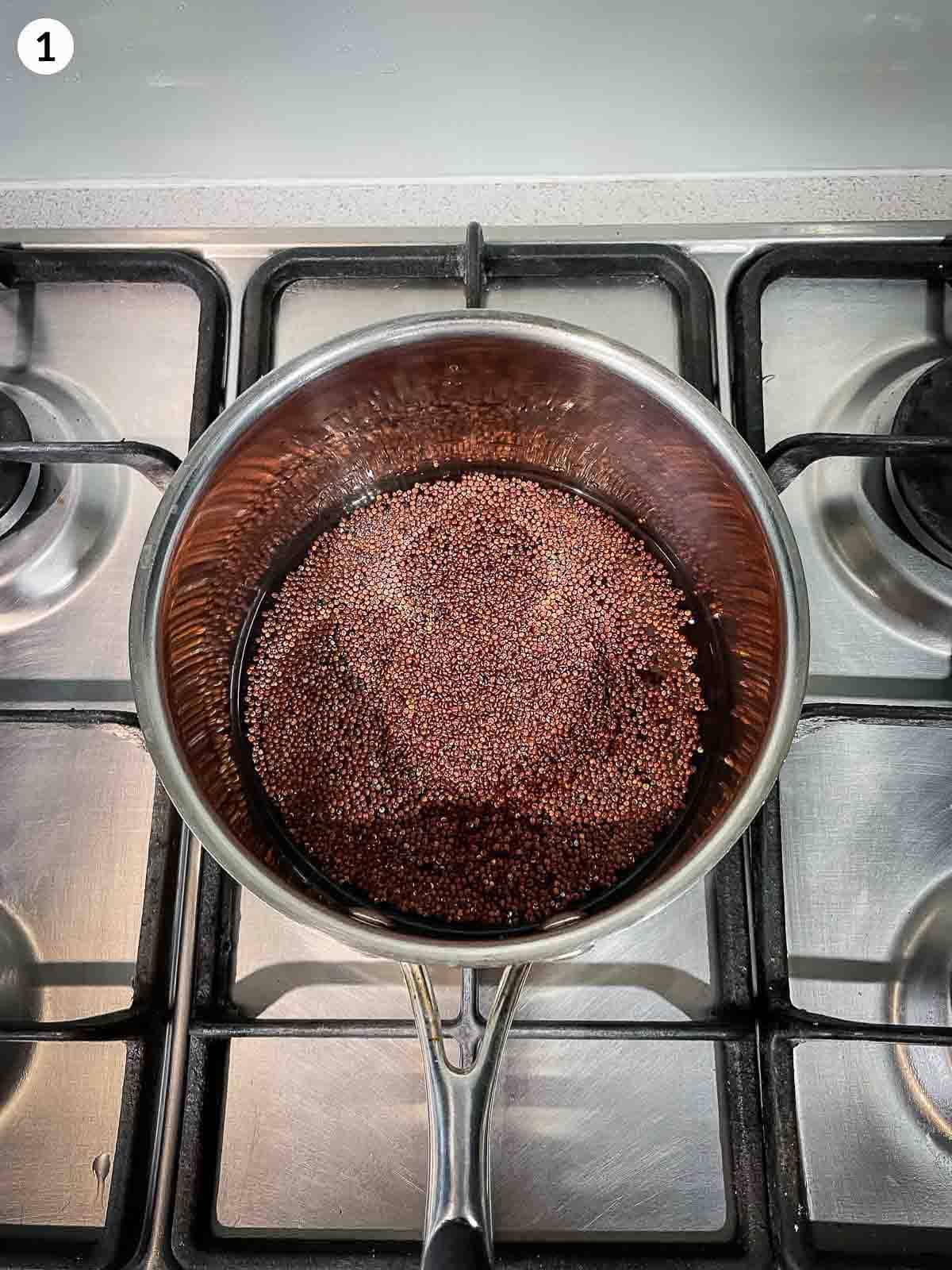 Cooking red quinoa in a stainless steel pot on a cook top