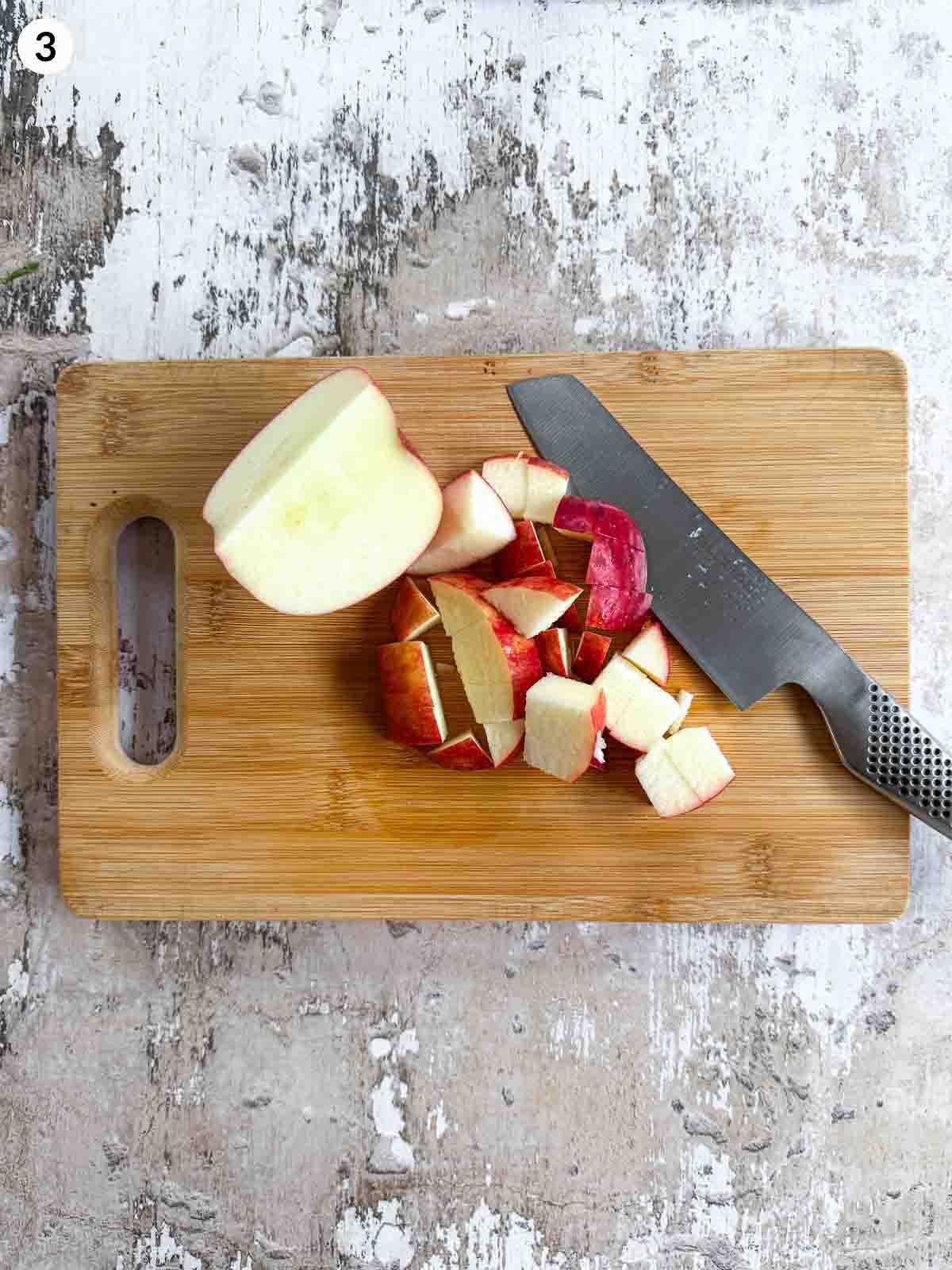 Cutting apples with a knife on a wooden chopping board