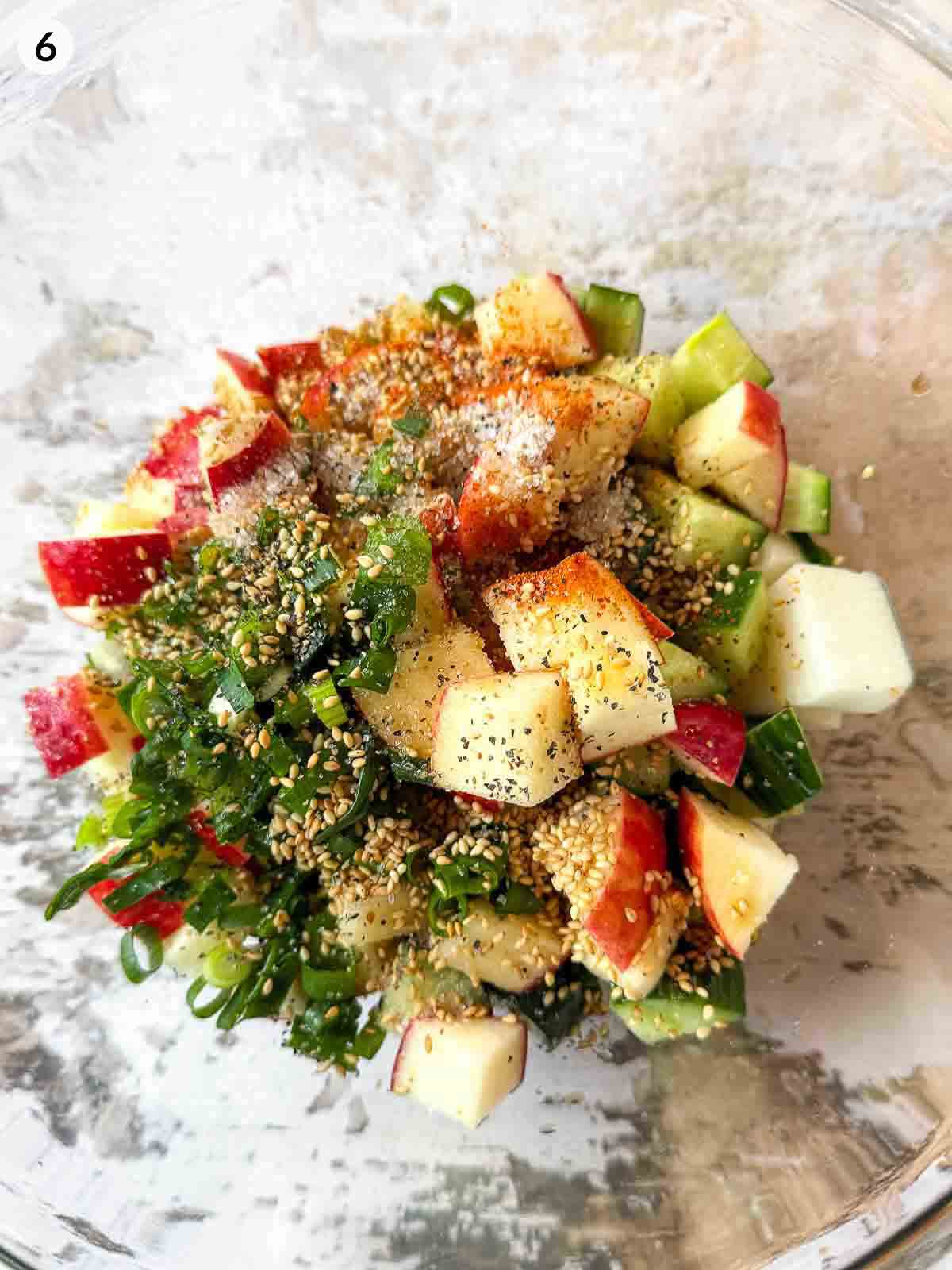 adding ingredients for Daikon Cucumber Apple Salad into a clear bowl