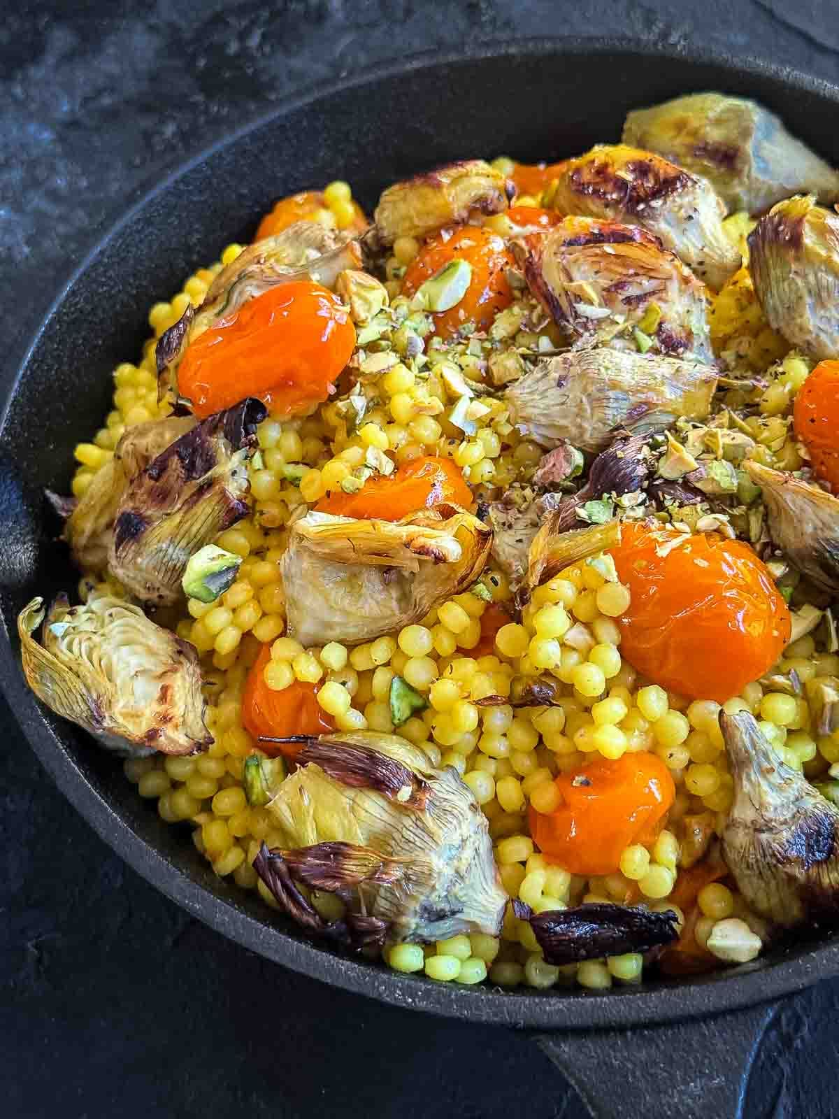 Saffron Israeli Couscous with Roasted Artichoke Hearts in a cast iron pan