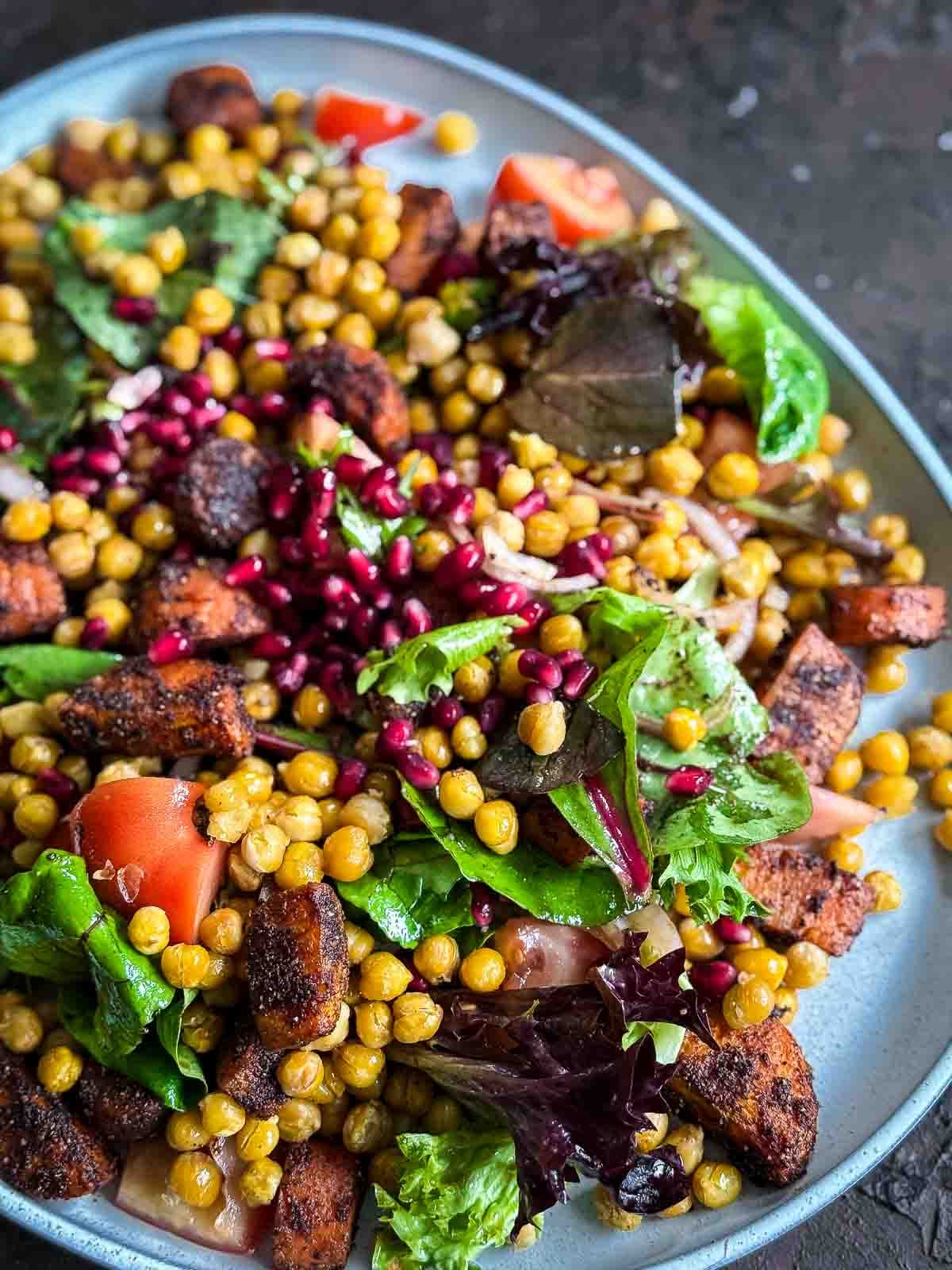 Roasted Chickpea and Carrot Baharat Salad on a grey platter against a dark background
