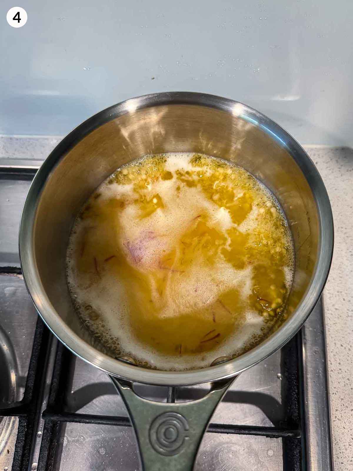 cooking israeli couscous in a stainless saucepan on a cooktop