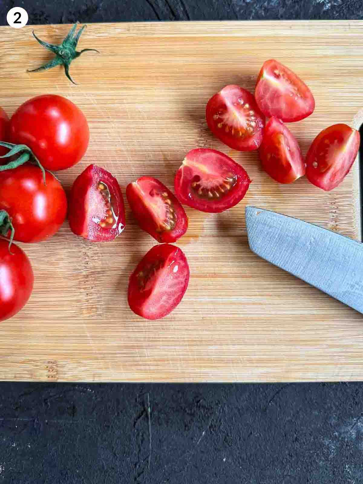 cutting tomatoes with a knife on a wooden chopping board