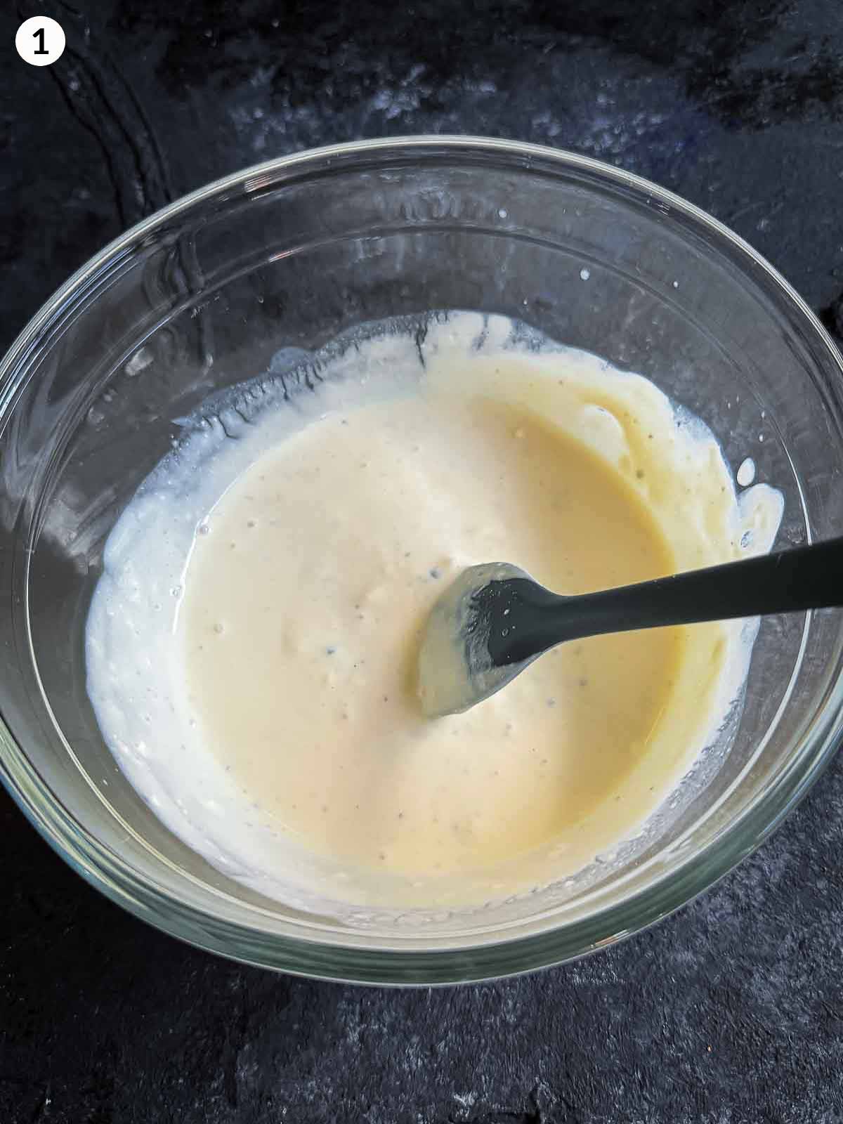 making blue cheese salad dressing in a bowl and stirring with a spatula