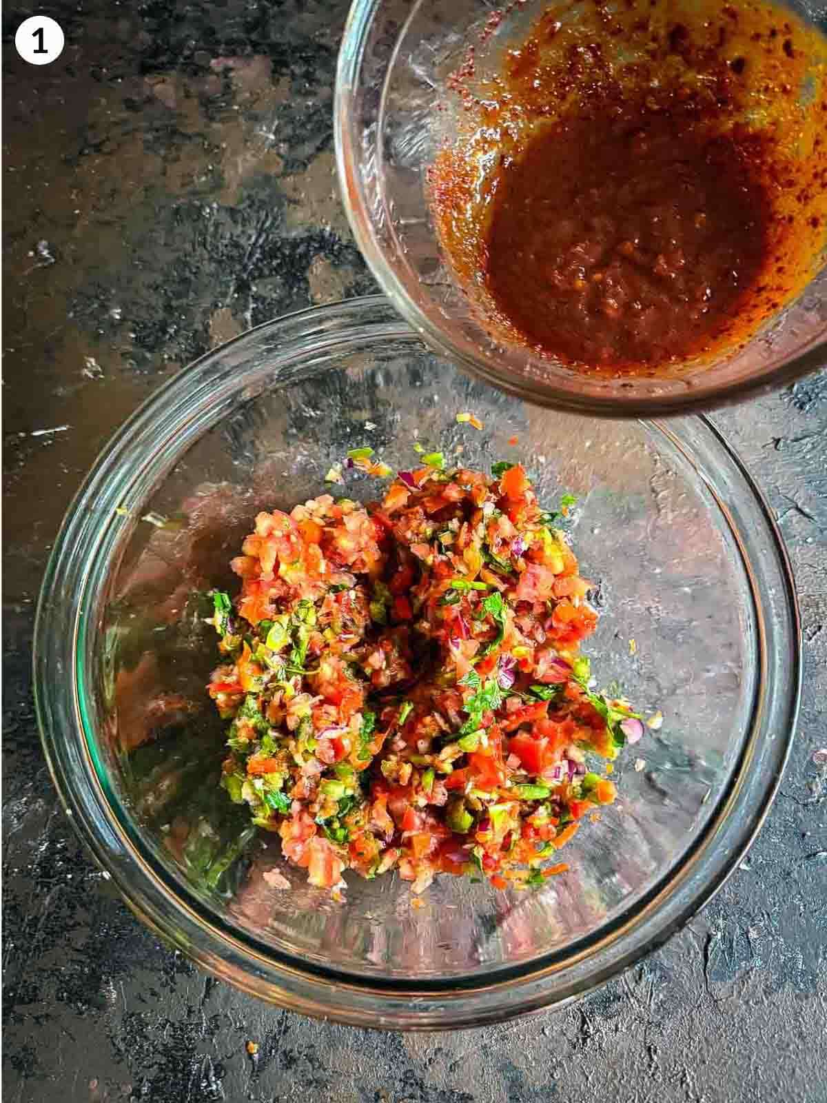 adding ezme salad sauce into chopped ingredients in a clear bowl