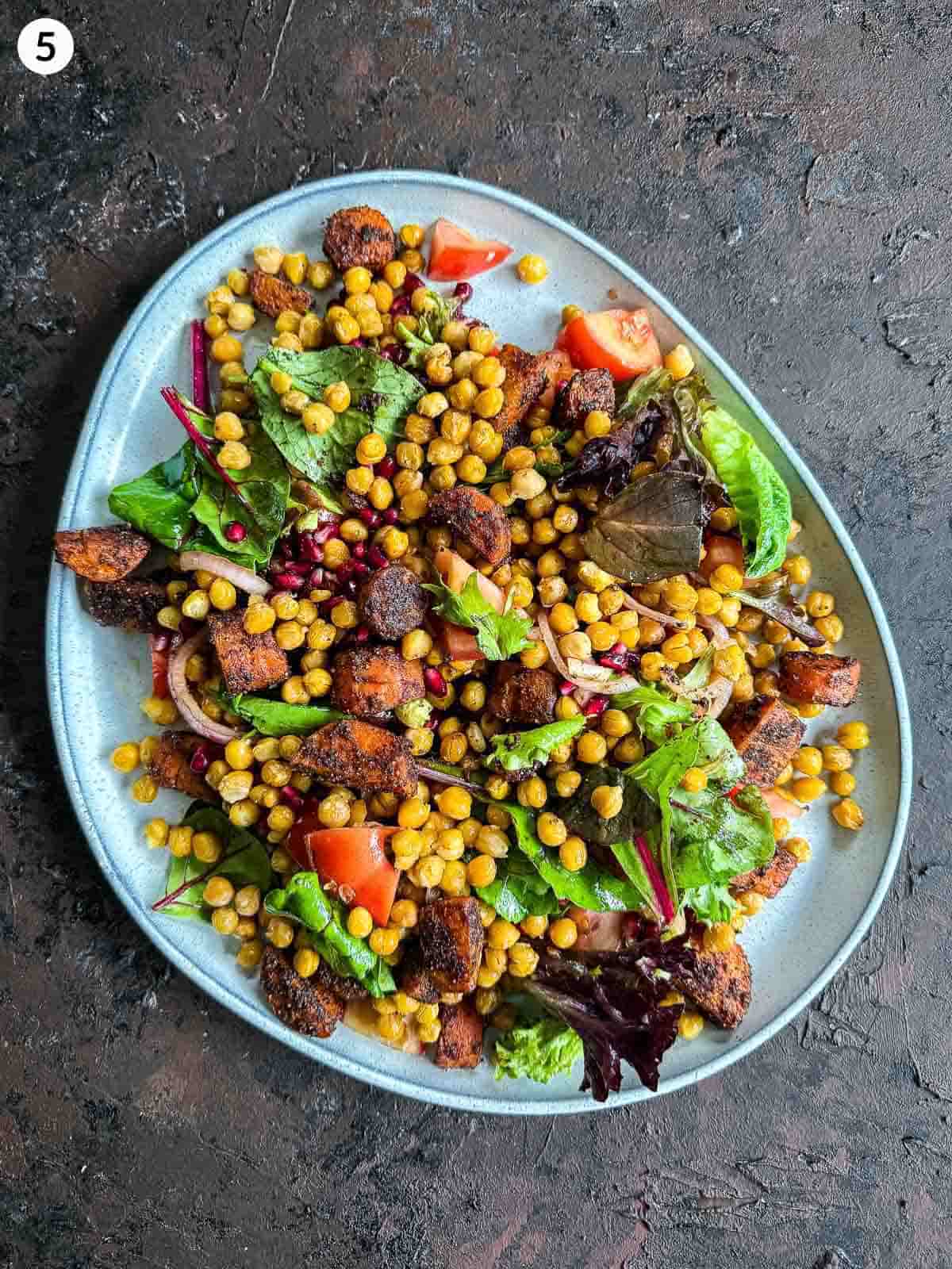Roasted Chickpea and Carrot Baharat Salad on a grey platter against a dark background