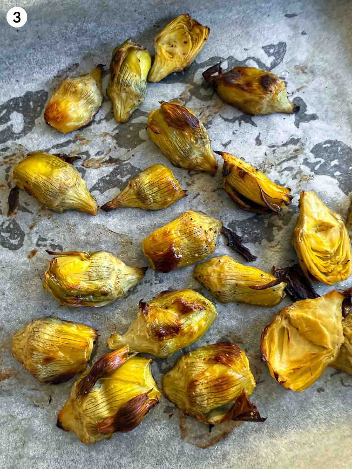 roasted artichoke hearts on parchment lined sheet pan