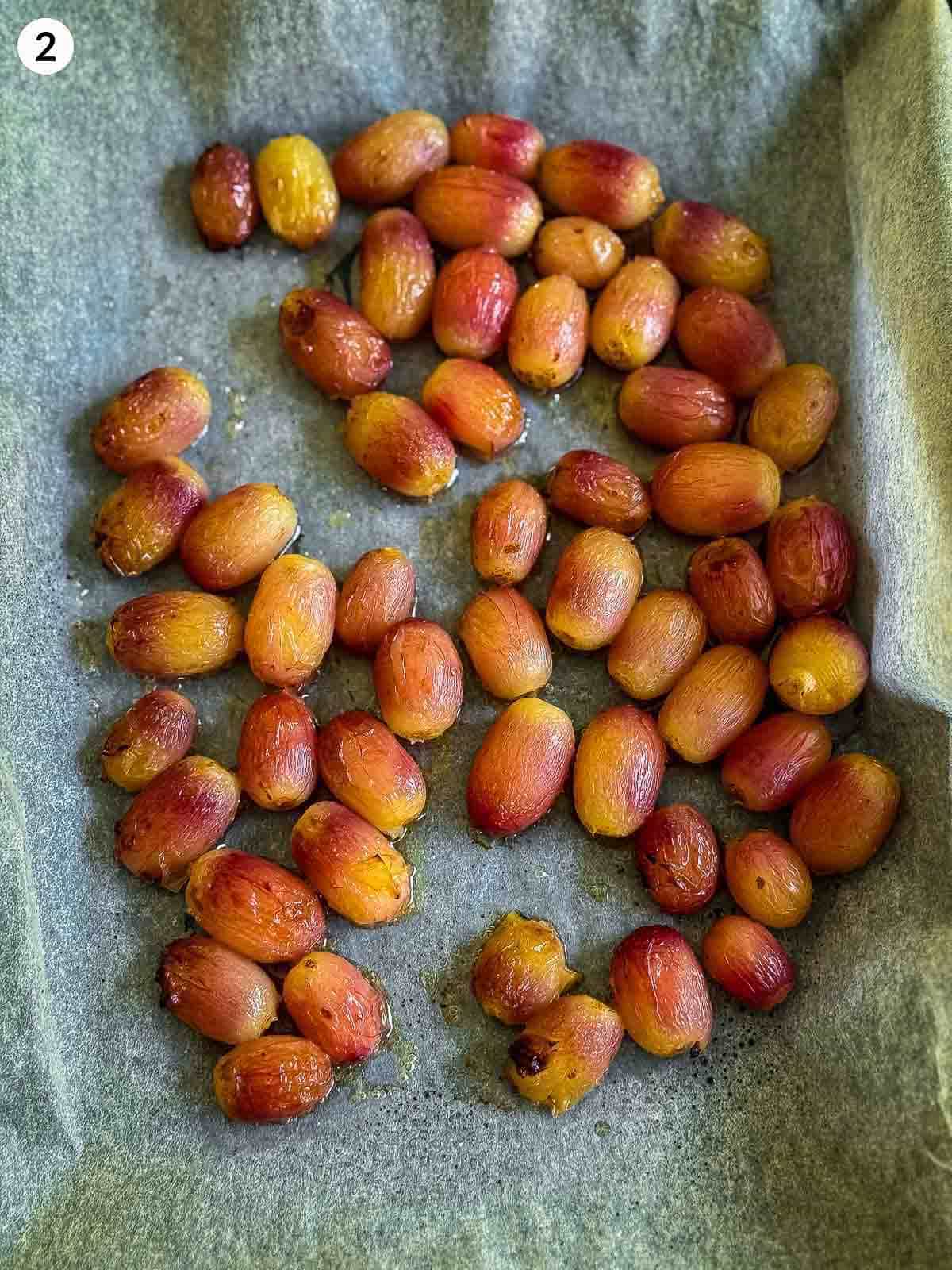roasted red grapes on parchment lined sheet pan